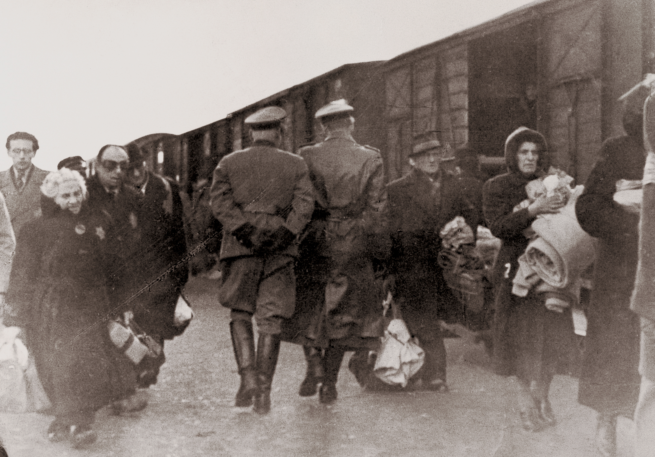 Joden en twee SS-ers bij een trein met bestemming Auschwitz of Sobibor. Kamp Westerbork, vanaf april 1943.