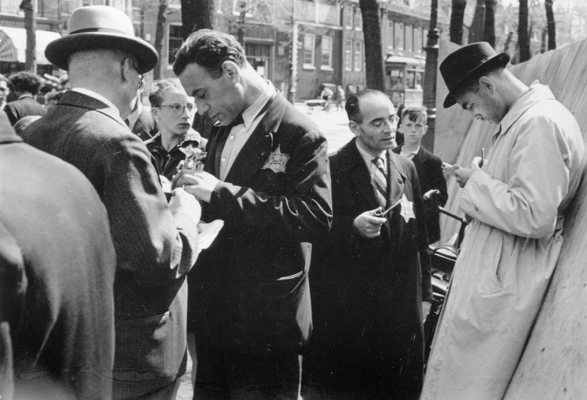 Agenten van de Sicherheitsdienst controleren de papieren van twee Joden. Amsterdam, juli 1942.