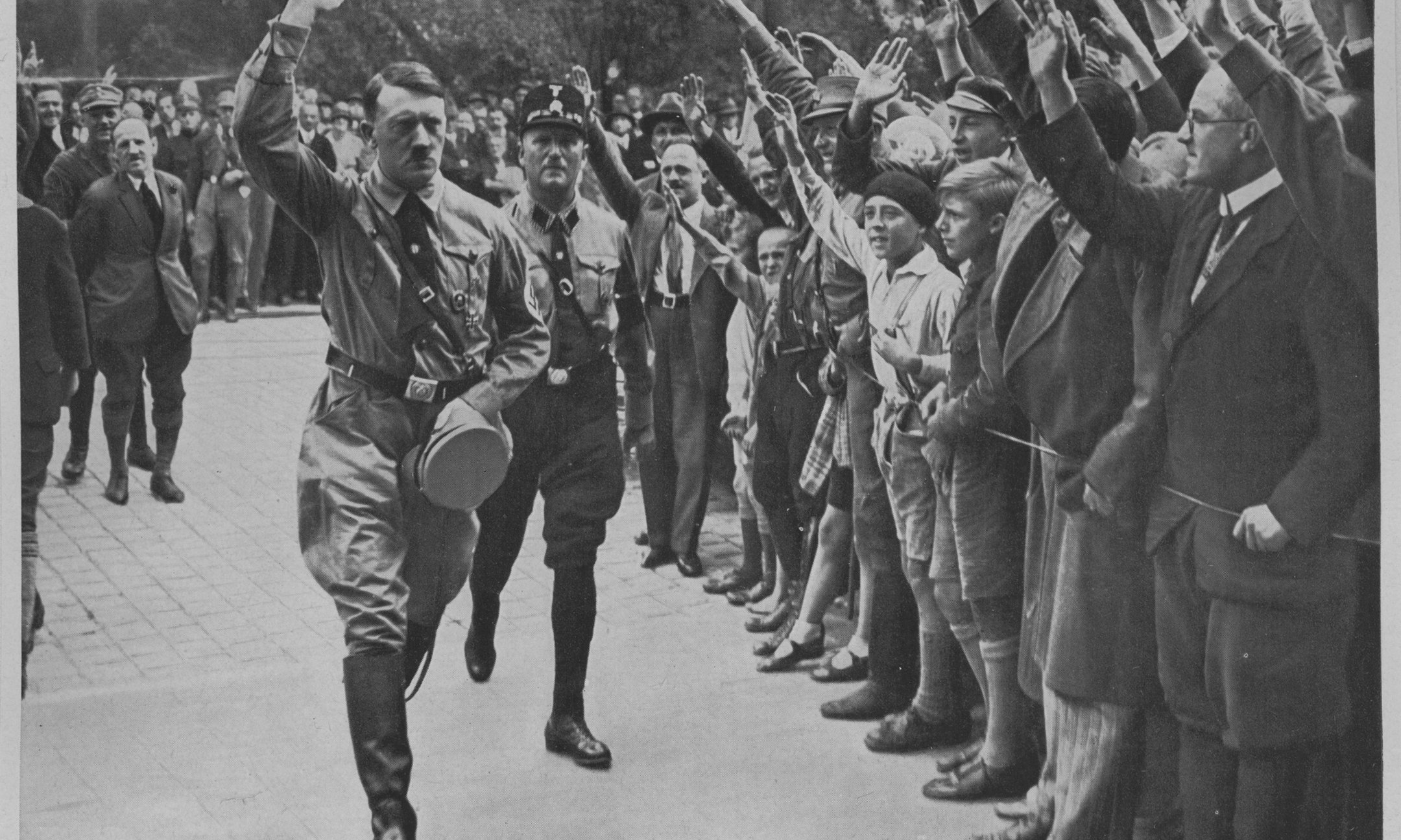Adolf Hitler's followers greet him at a party conference in Neurenberg (1929). This and other pictures came with packets of cigarettes and were collected in special albums. This picture is from the series Deutschland erwacht [Germany awakes].