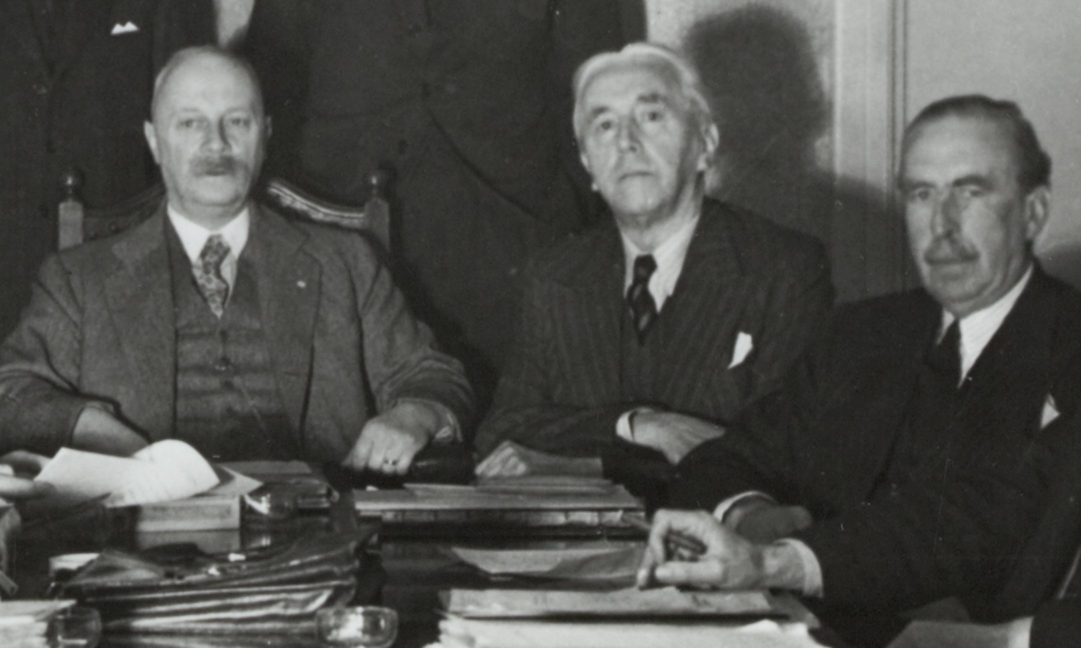Minister G. Bolkestein tussen Minister-President P. Gerbrandy (l) en Minister E. Michiels van Verduynen (r) tijdens een ministerraadsvergadering.
London, Verenigd Koninkrijk, 1944.