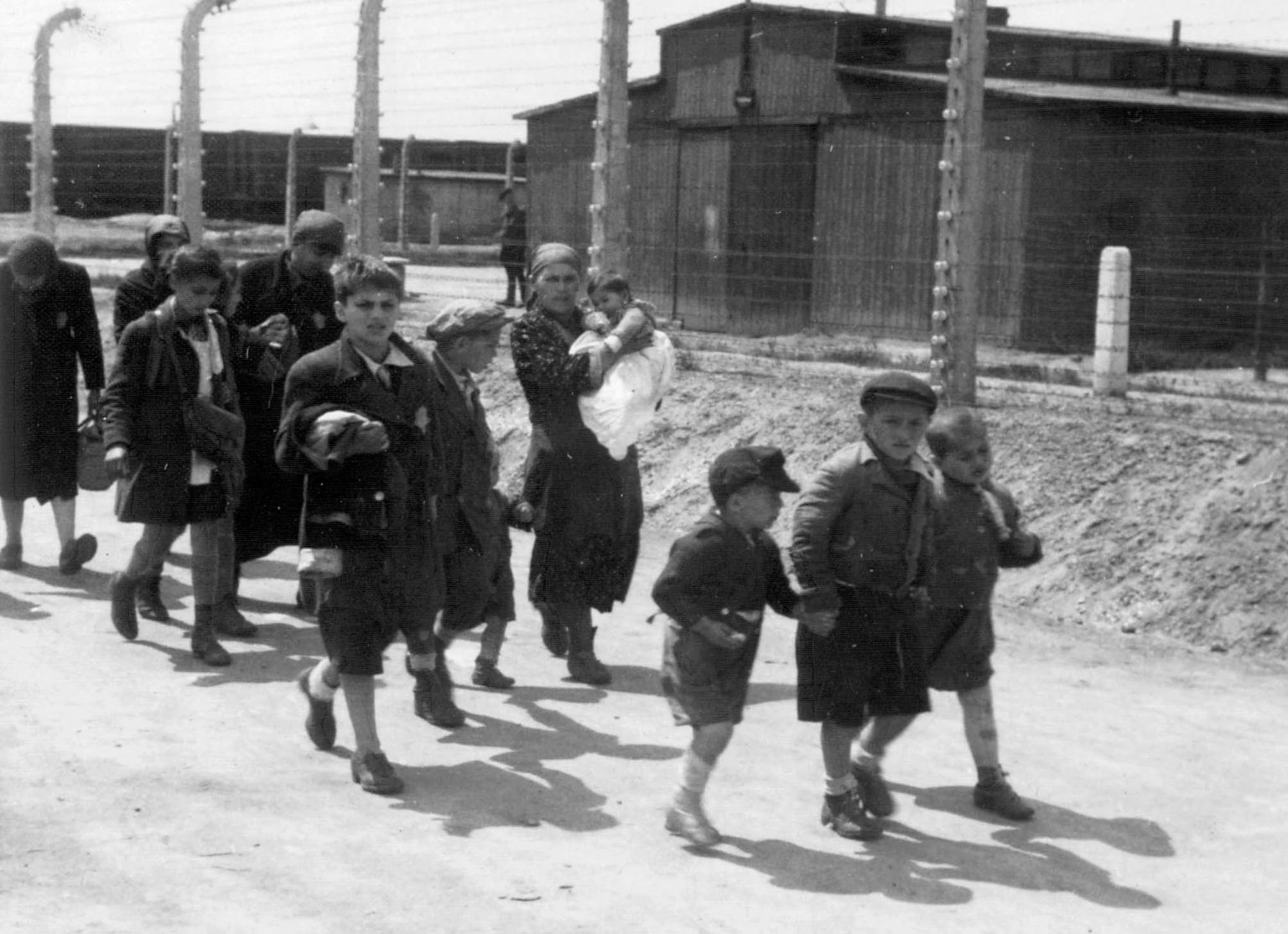 Ungarische Frauen und Kinder auf dem Weg in die Gaskammer nach ihrer Ankunft in Auschwitz-Birkenau. 26. Mai 1944.
