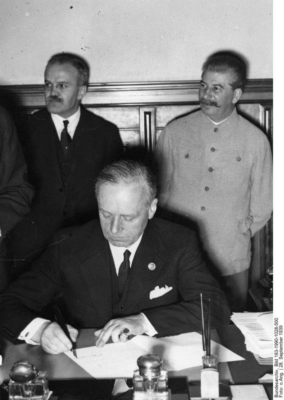 The German minister Joachim von Ribbentrop signs the non-aggression pact between Germany and the Soviet Union. Behind him are Russians Vyacheslav Molotov, Minister of Foreign Affairs, and Joseph Stalin, supreme leader of the Soviet Union. Moscow, 23 August 1939.
